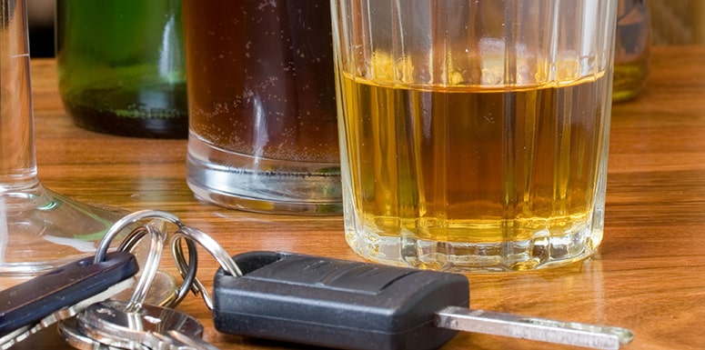 Car keys with alcohol glasses on table