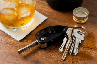 Alcohol glass and keys on table