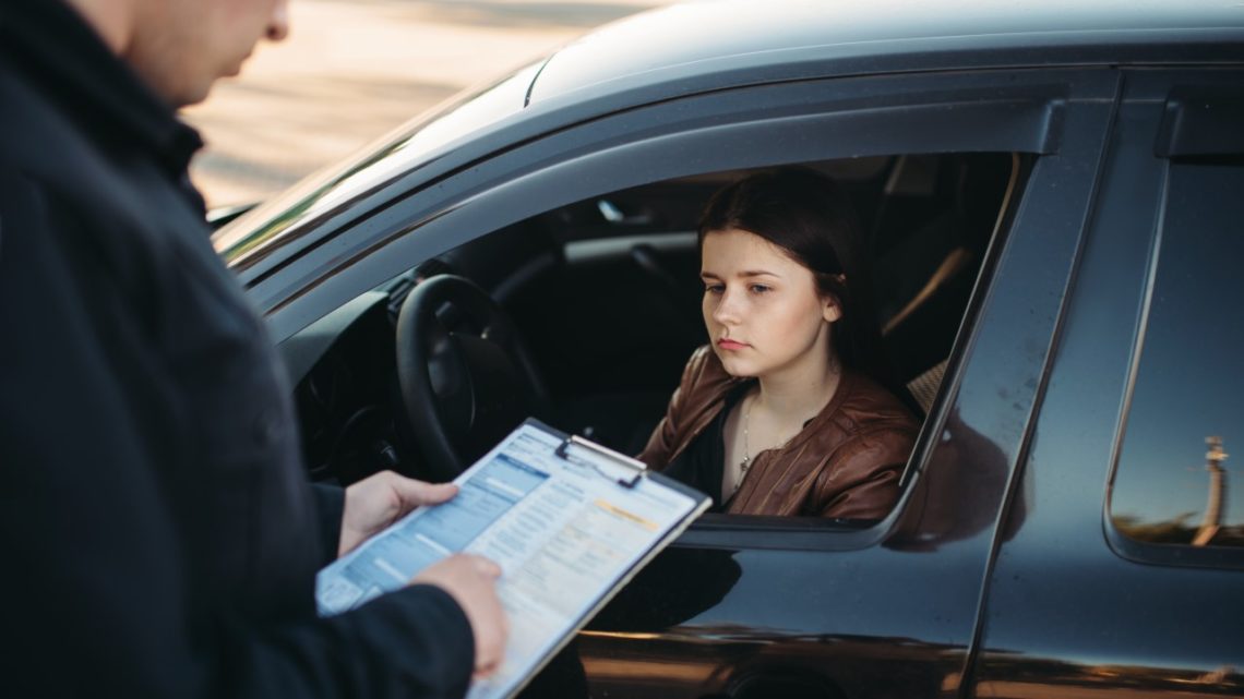 Woman in car getting a ticket from police pennsylvania points system, PennDOT drivers license point system